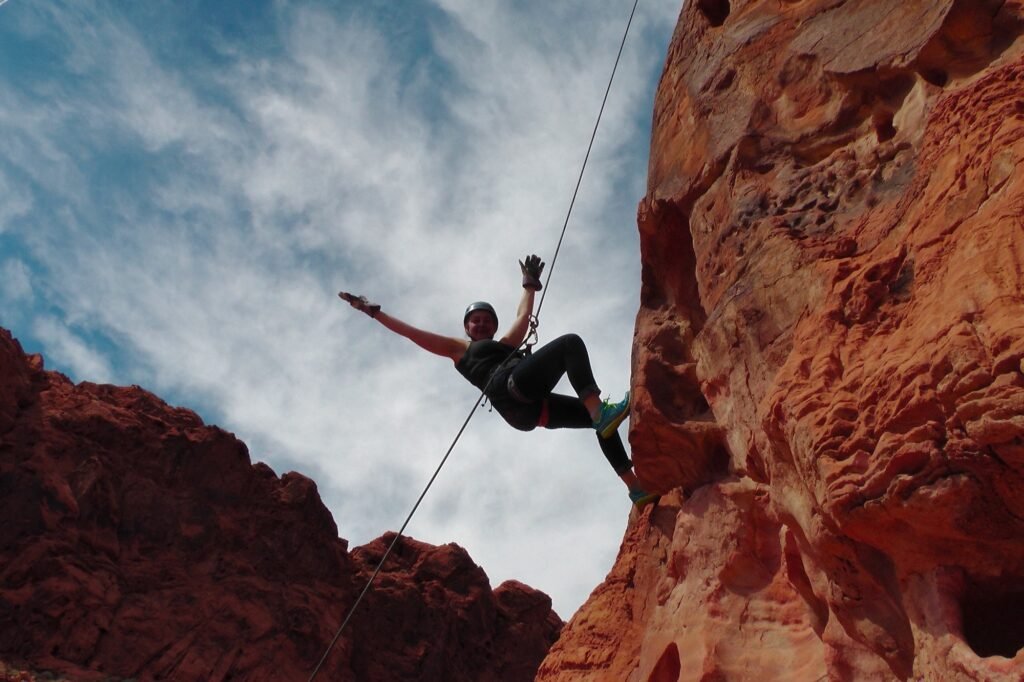 Adventurous woman practicing mountain climbing, outdoor activities, rusk takers, achievements