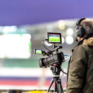 cameraman with a professional video camera on the broadcast of a football match