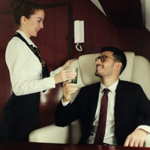 Young billionaire travelling first class, flight attendant is bringing him glass of champagne
